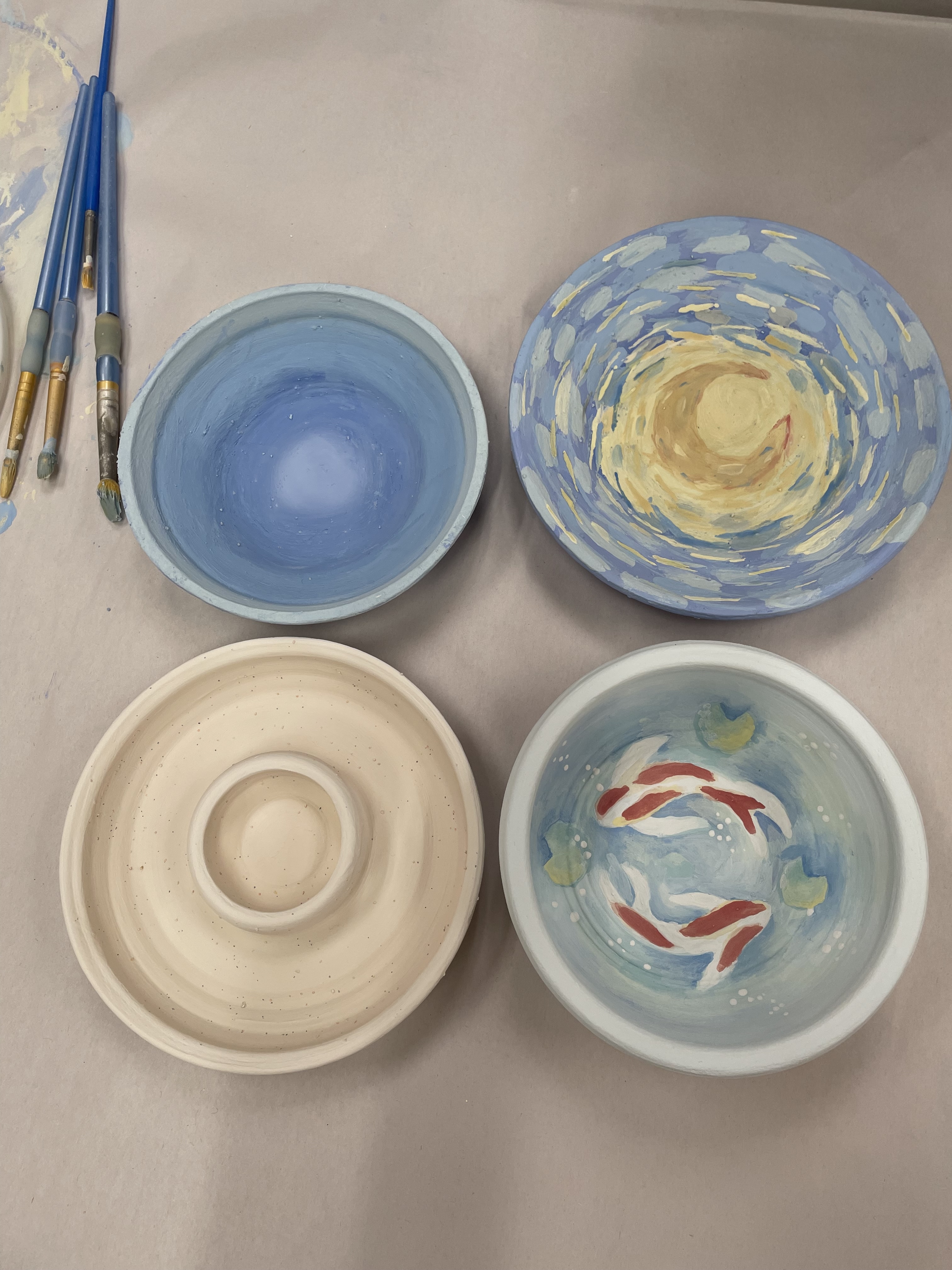 A table covered in pottery pieces and tools in a studio.